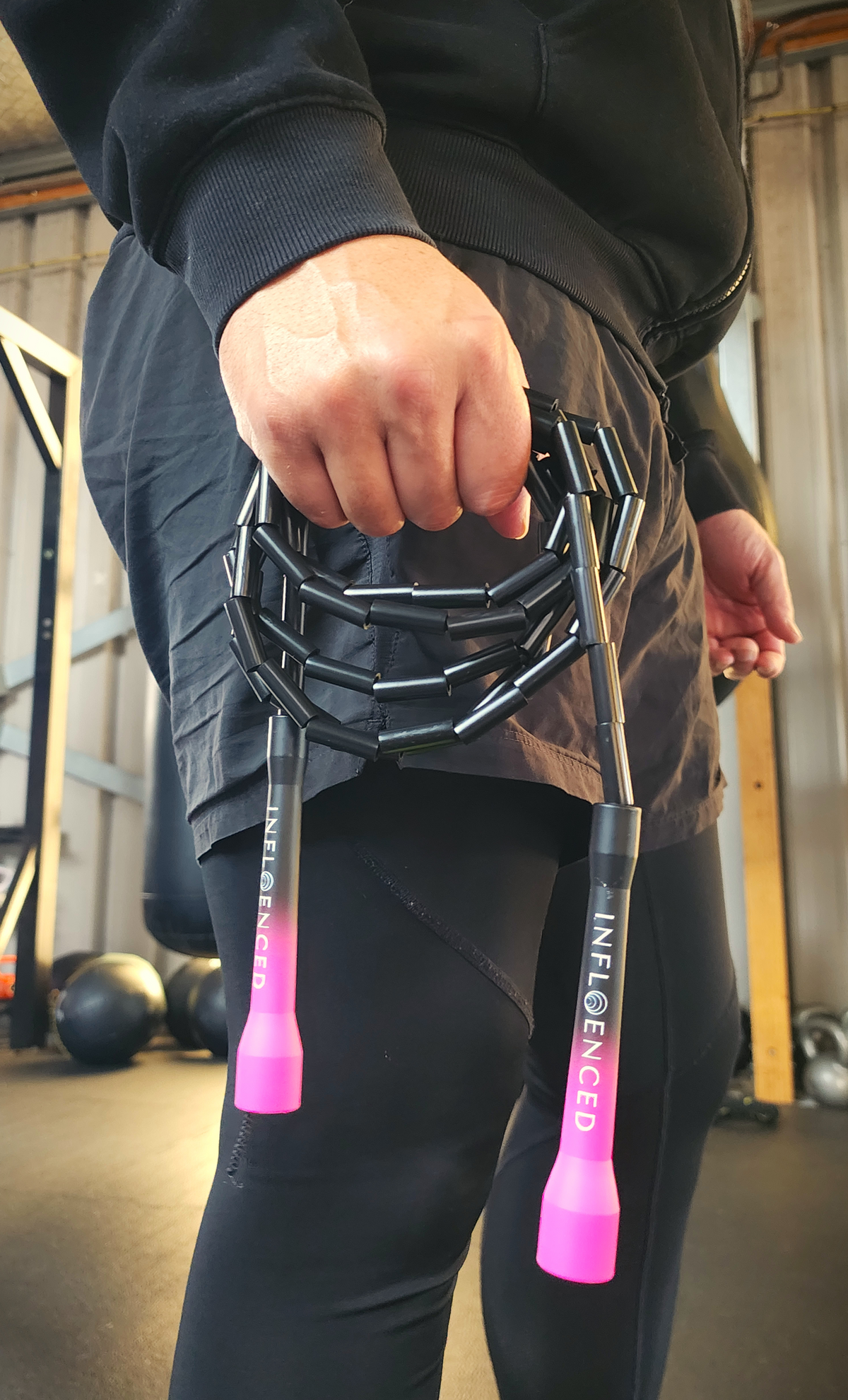 A person in a boxing gym holding a black and pink beaded jump rope by Infloenced