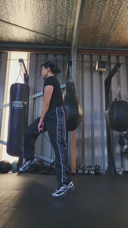a girl skipping in a boxing gym practicing releases and coordination with a black and pink beaded jump rope