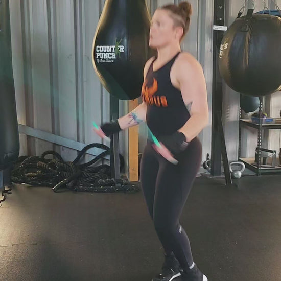 a girl skipping in a boxing gym practicing speed and footwork with a teal green and grey pvc jump rope