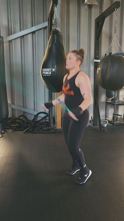 a girl skipping in a boxing gym practicing speed and footwork with a teal green and grey pvc jump rope
