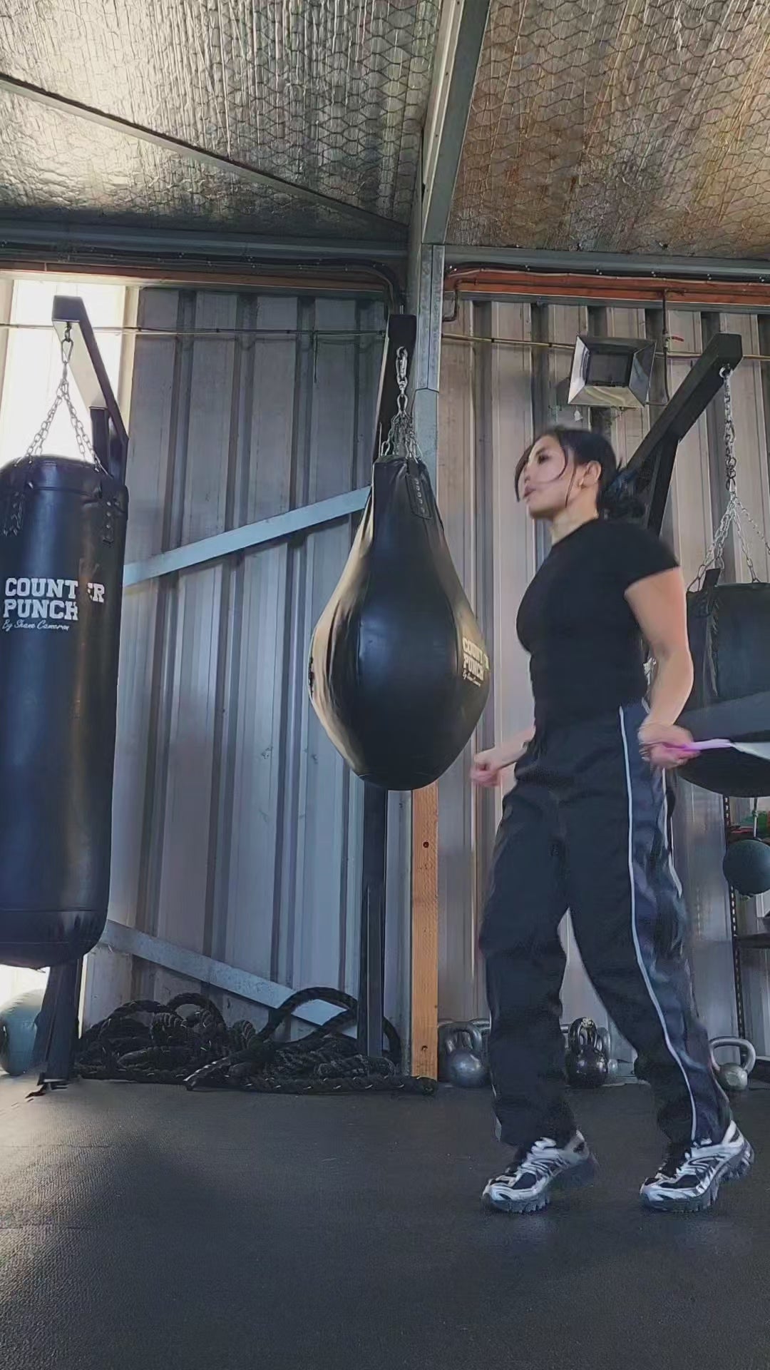 a girl skipping in a boxing gym practicing releases and coordination with a white and pink beaded jump rope
