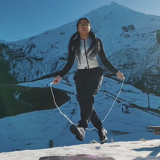 A girl skipping on a snowy winter mountain in New Zealand