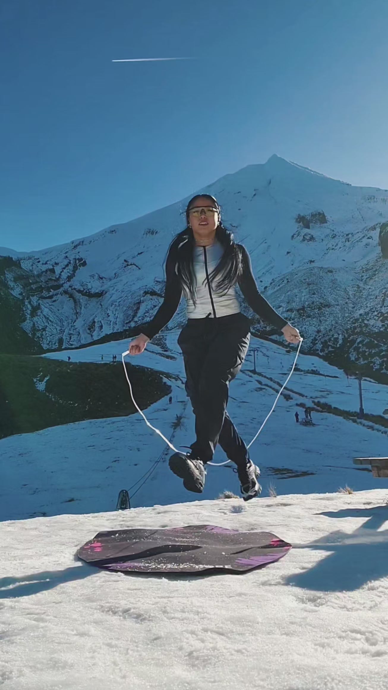 A girl skipping on a snowy winter mountain in New Zealand