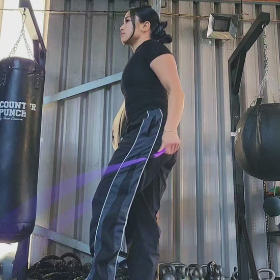 a girl skipping in a boxing gym practicing releases and coordination with a purple and blue beaded jump rope