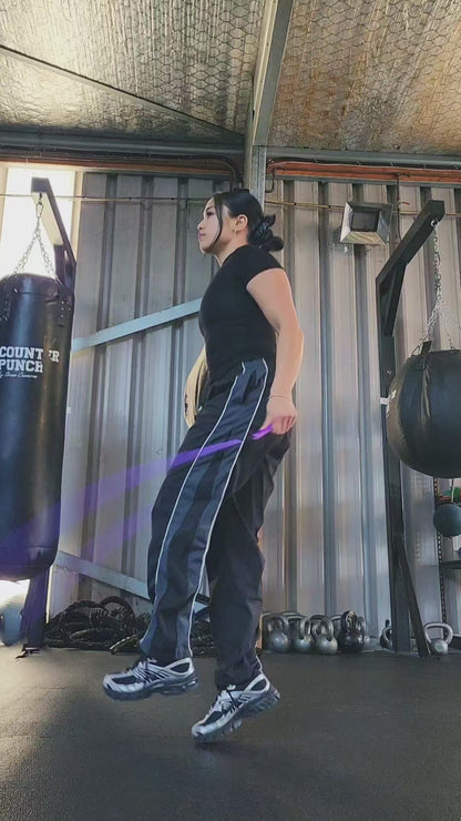 a girl skipping in a boxing gym practicing releases and coordination with a purple and blue beaded jump rope