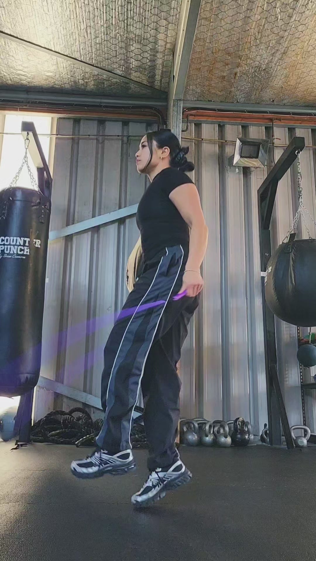 a girl skipping in a boxing gym practicing releases and coordination with a purple and blue beaded jump rope
