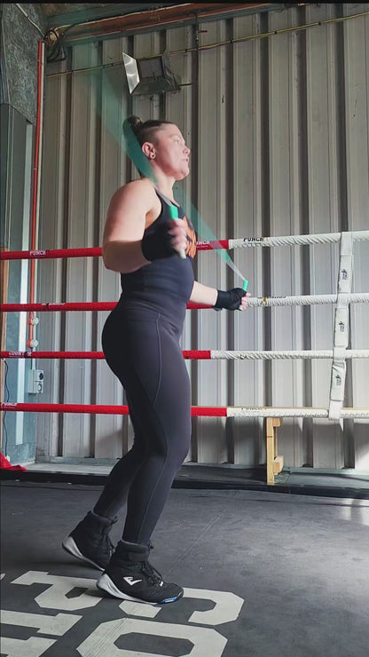 a girl skipping in a boxing gym practicing footwork and coordination with a teal green and grey beaded jump rope