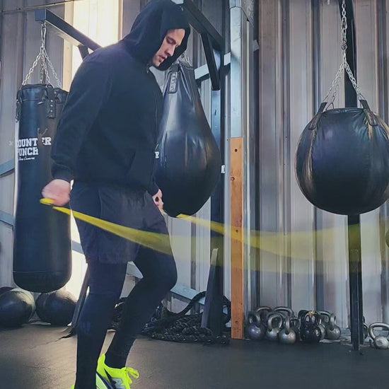a person skipping in a boxing gym practicing rhythm and coordination with a yellow and black beaded jump rope