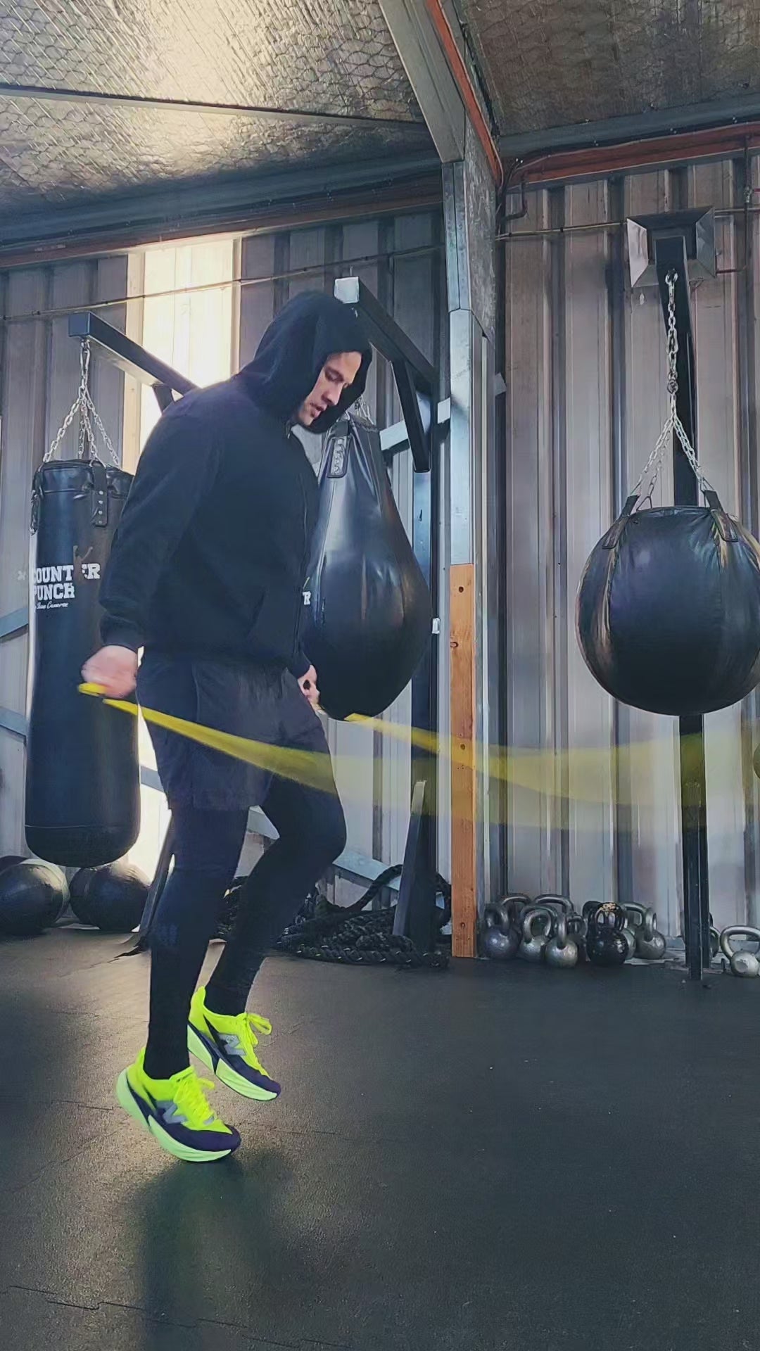 a person skipping in a boxing gym practicing rhythm and coordination with a yellow and black beaded jump rope